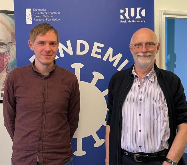 Maarten og Viggo fra PandemiX der står foran PandemiX blå skilt