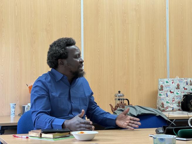 Project member sitting at a table presenting