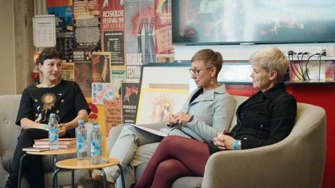 lektor Jo Krøjer, lektor Marta Padovan-Özdemir og forfatter Shekufe Heiberg sidder i lænestole til passiar med pejs på skærmen i baggrunden.l