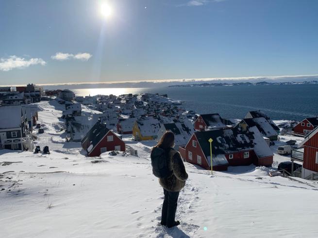 Student looking at Nuuk city from a hill 